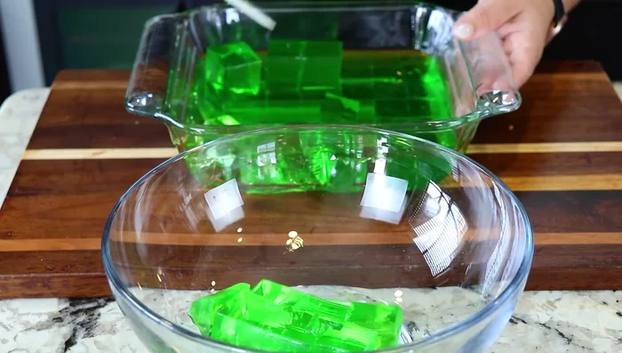 Cut and Layer Jello: Once firm, cut the chilled Jello into squares.
