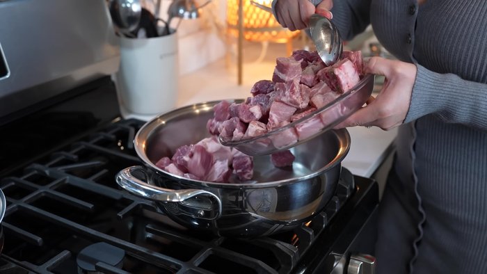 Cook the pork: In a pot over medium heat, add pork shoulder, ribs, salt, bay leaves, minced garlic, and a small piece of onion. Cover with water and bring to a simmer. Simmer for 40 minutes, or until the water evaporates.