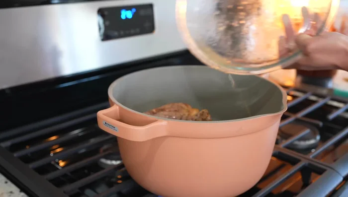 Return the browned pork to the pot. Add the adobo sauce, mix well, and add two bay leaves.