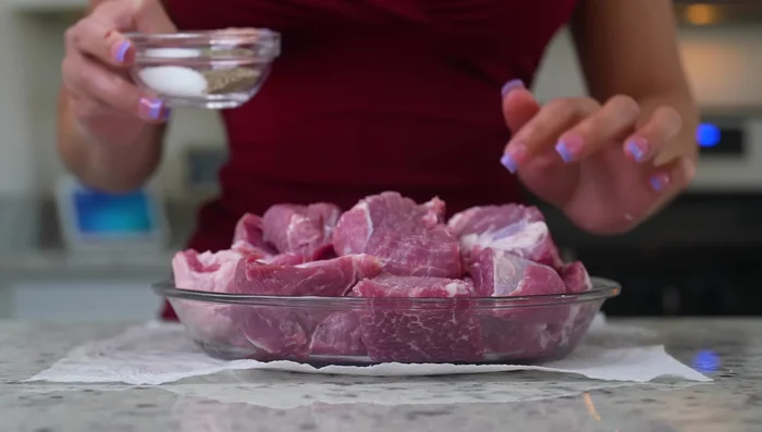 Season the pork cubes with salt and pepper.