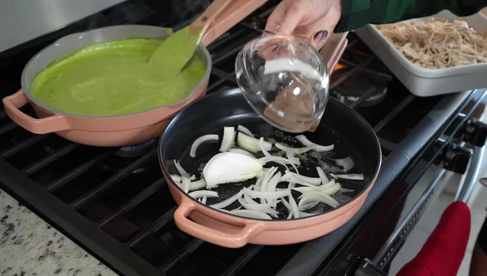 In a skillet, sauté half an onion, corn, and shredded chicken for a couple of minutes.