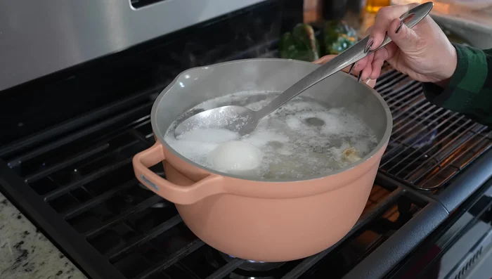 Remove impurities from boiling chicken. Reduce heat to medium-low, cover, and cook for 25 minutes.