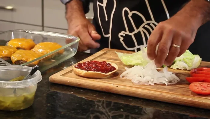 Layer the cooked tuna patty, onion, lettuce, tomato, and pickled jalapeños.
