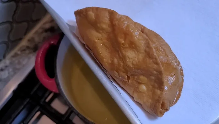 Remove the chalupas from the oil and let them drain on a baking sheet.