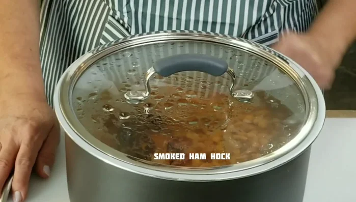 Refry the pinto beans with ham hocks. (Use bacon grease or vegetable oil in a skillet)