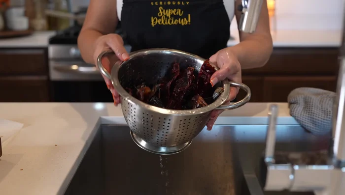 Add cleaned chilies to the broth and simmer for 5 minutes to soften.