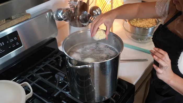 Add onion, garlic, bay leaves, and soaked hominy. Reduce heat to medium-low, cover, and simmer for 1.5 hours.