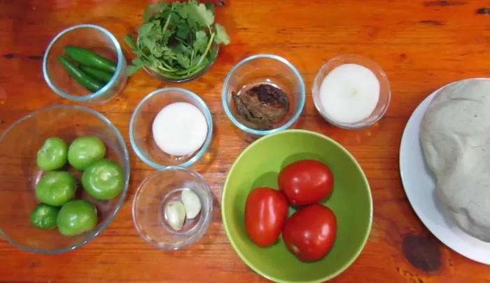 Prepare the green sauce: Blend green tomatoes, serrano chiles, cilantro, onion, garlic, and water. Add salt to taste.