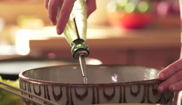 Prepare a vinaigrette by whisking together olive oil, vegetable oil, white vinegar, salt, pepper, and a pinch of sugar.