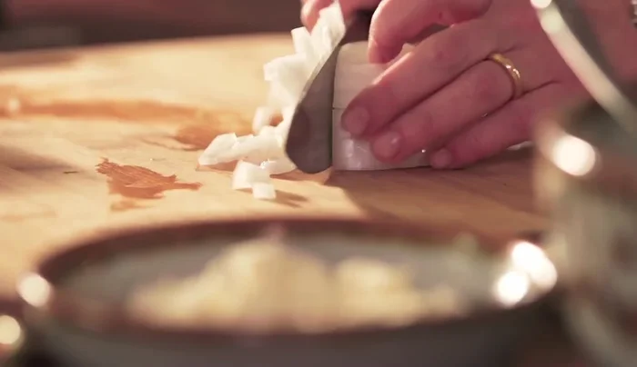 Prepare the topping: Crumble queso fresco and mix with chopped onion.