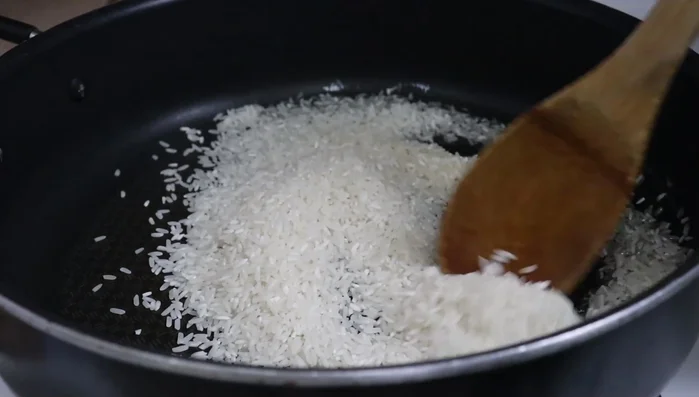 Add rice to the pan and continuously stir for 5 minutes until golden brown.