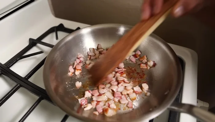 Stir-fry bacon in a skillet until crispy. Add onions and cook until softened, releasing their moisture.