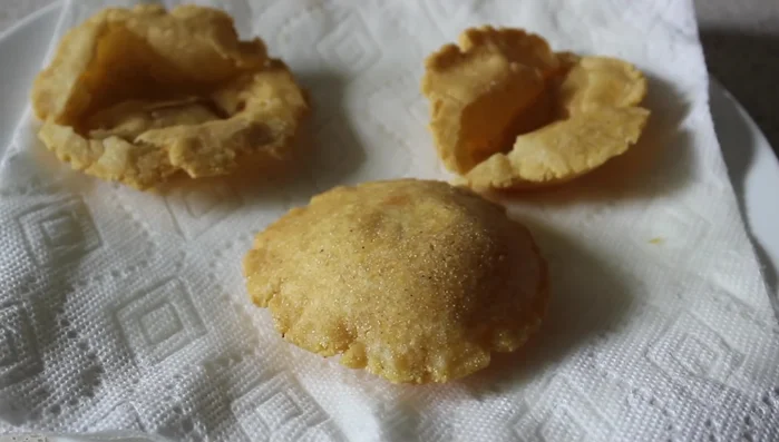 Remove the puffy taco shell from the oil and drain on a paper towel.