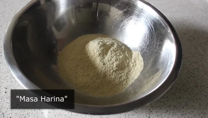 Combine masa harina, salt, and tepid water in a bowl. Mix with your hands until a dough ball forms.