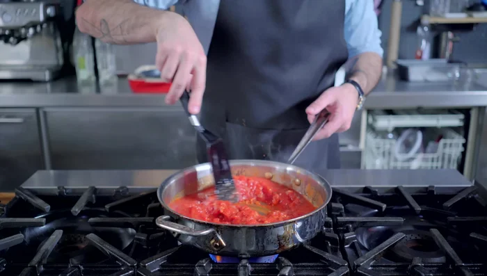 Add tomatoes and basil to the pan. Simmer on low heat, stirring every 10 minutes, for about an hour.