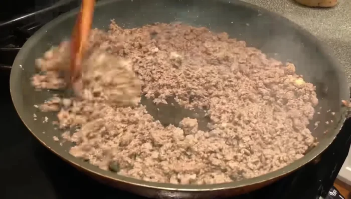 Season the meat. Add 1 tablespoon of garlic paste and 6 tablespoons of taco seasoning mix (adjust to your spice preference). Stir well to combine.