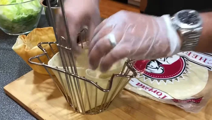 Make the tortilla bowls. Place a tortilla wrap into the tortilla bowl maker, press down firmly, and carefully lower it into the hot fryer for a few seconds until golden brown. Remove and let cool; they will crisp further as they cool.