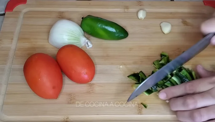 Chop the poblano pepper, jalapeño pepper (remove seeds and veins), tomatoes, onion, and garlic into small pieces.