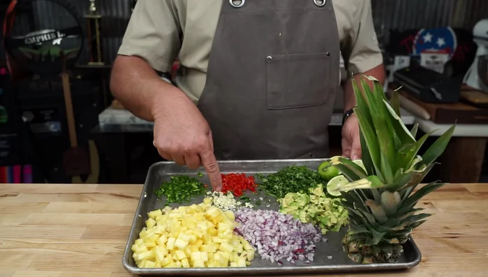 Prepare the pineapple salsa: Dice pineapple, jalapenos, garlic, red peppers, red onion, avocado, and cilantro. Mix with lime juice and salt.