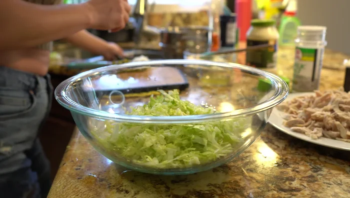 In a large bowl, combine lettuce, vegetables, chicken, sour cream, mayonnaise, jalapeño juice, garlic salt, and black pepper.