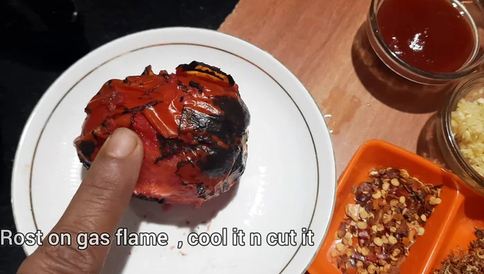 While the soup is making, roast the tomatoes and bell peppers directly on a gas flame. Once cooled, finely chop them.