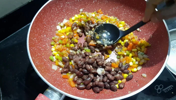 Stir in the boiled kidney beans. Mash slightly and mix thoroughly. Season with salt, half the amount of red chili powder, chili (optional), chili flakes, and any other desired seasonings.