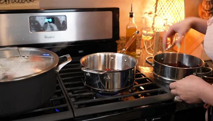 While the meat simmers, prepare the adobo sauce: In a small saucepan, combine 22 New Mexico ancho chiles, 3 chile anchos, and chile de arbol. Cover with water and bring to a boil. Once boiled, remove from heat and blend.