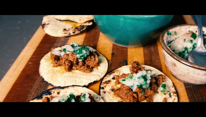Assemble the tacos: Fill the tortillas with the cooked beef and the prepared topping.