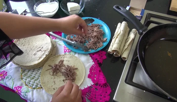 Prepare the tacos: Place shredded beef (or ham, or other filling) onto a tortilla.