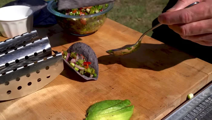 Assemble the tacos: layer pico de gallo, sliced steak, paddle cactus, and avocado slices on the tortillas.