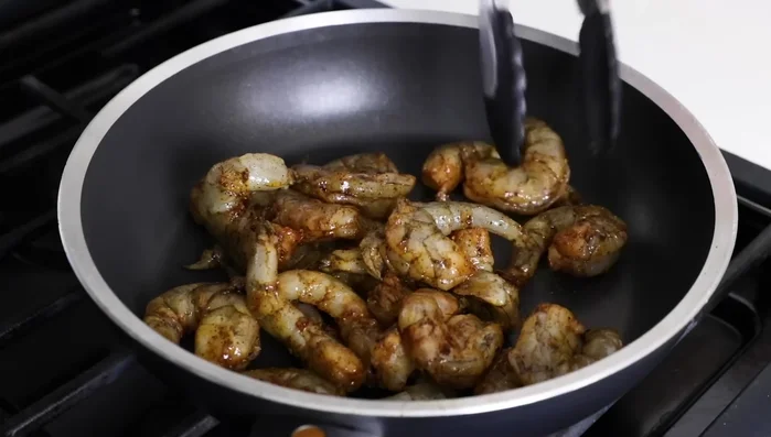 Cook shrimp: Heat a pan over medium heat. Add shrimp and cook for 1-2 minutes per side, until pink and opaque. (256.959)