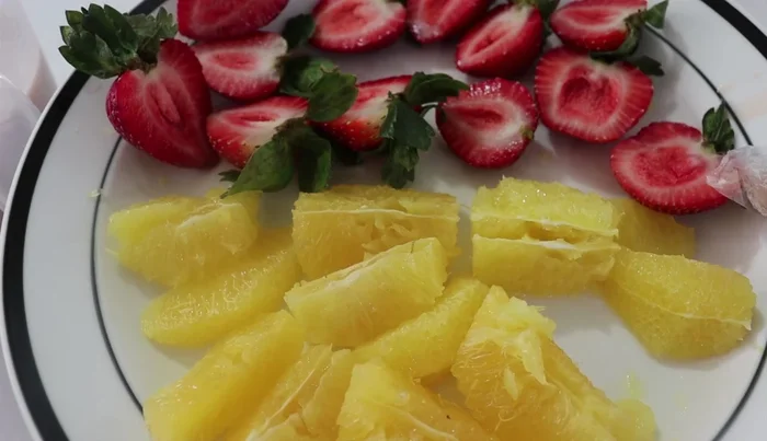 Prepare the fruit: Cut oranges into segments, removing seeds and bitter white parts. Halve strawberries and prepare nuts.