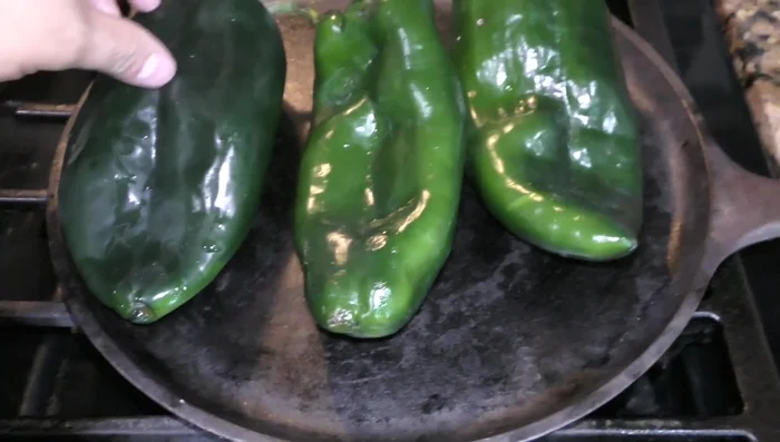 Roast the poblano peppers on a comal or skillet until well done on both sides (94.439). Place them in a plastic bag to sweat and then peel them (104.82).