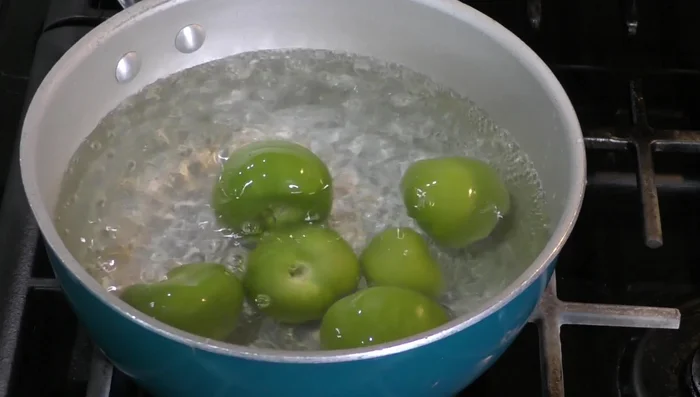 Boil tomatoes and chiles for a few minutes until color changes.