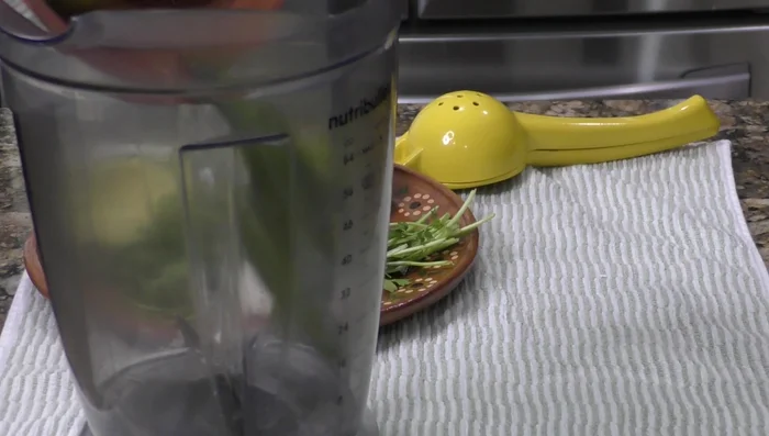 Blend boiled tomatoes and chiles with a quarter onion, garlic clove, cilantro bunch, avocado, lemon juice, salt, and olive oil to create the green avocado sauce.