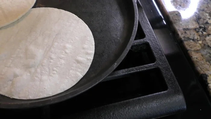 Heat corn tortillas on a comal or in the microwave until soft.