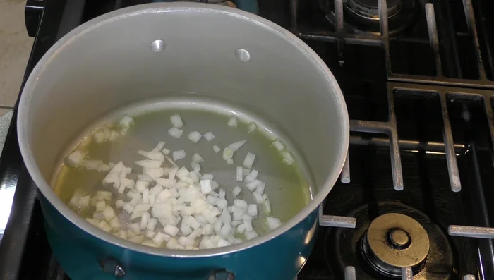Heat a little oil in a pot. Add the chopped onion and sauté until it turns translucent. Add the blended tomato sauce and let it simmer.