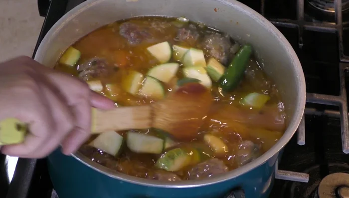 After 20 minutes, add the zucchini and the remaining two serrano chilies. Stir in the remaining cilantro and additional salt to taste. Cook for about 12 minutes, or until zucchini is tender.