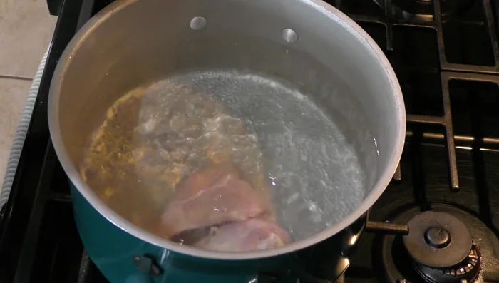 In a pot, combine chicken, 2.5 liters of water, half an onion, 2 cloves garlic, cilantro and a little salt. Bring to a boil and remove foam.