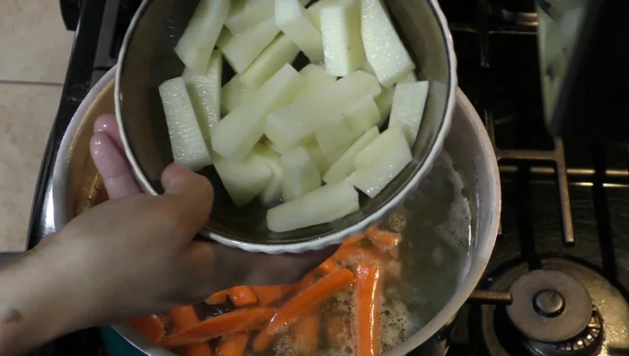 Add carrots and potato to the broth.