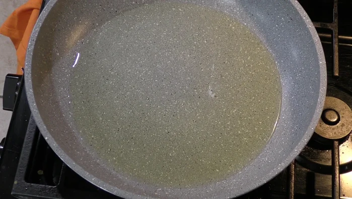 Fry the corn tortillas in hot oil until slightly crisp.