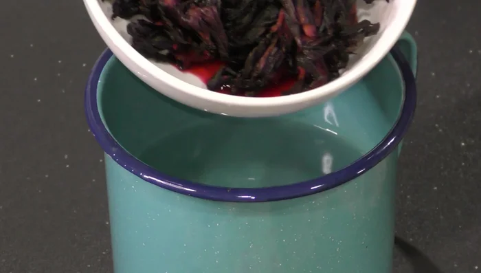 Steep hibiscus flowers in hot water in a pot. Let it sit to release color.