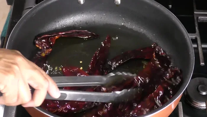 Fry guajillo, pasilla/ancho, and puya chiles until softened. Be careful not to burn them.
