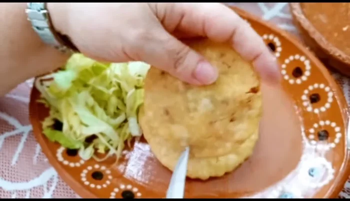 Assemble the gorditas: Once cool, slice the gorditas open. Add sauce, lettuce, cheese, and cream. (471.56)