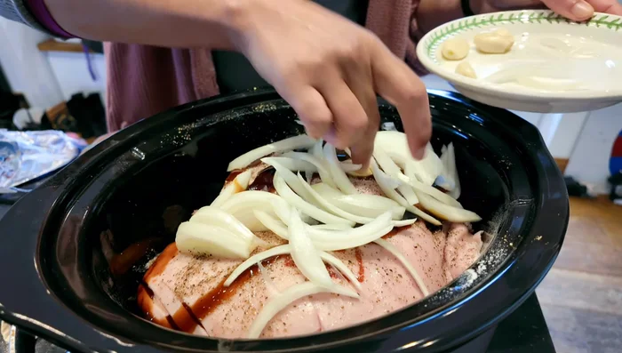 Add chopped onions and crushed garlic over the seasoned pork.