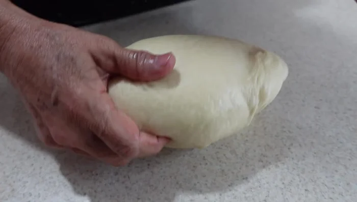 Divide the risen dough into 70g portions. Shape each portion into a ball.
