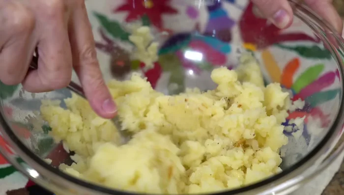 Mix mashed potatoes, sautéed onion, tuna, parsley, egg, salt, pepper, and breadcrumbs.