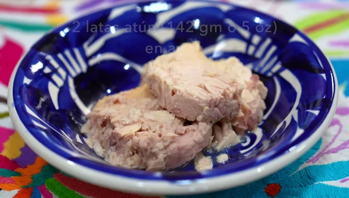 Prepare spicy tuna salad: Combine tuna, lettuce, cucumber, radishes, red onion, jalapeños, cilantro, tomatoes, avocado, and a dressing of mayonnaise, mustard, garlic, oregano, salt, pepper, lemon juice, chili vinegar, and olive oil.