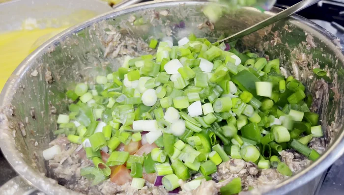 Add chopped onions and green onions to the chicken and bean mixture. [175.84]
