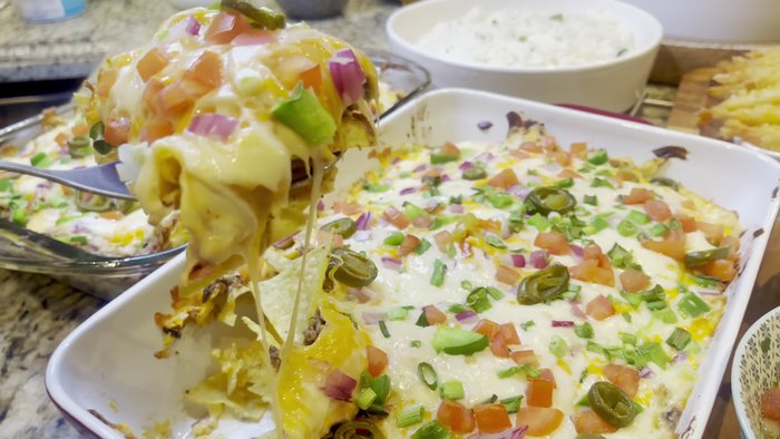 Assemble nachos: Layer tortilla chips with the chicken-bean mixture, cheese, and salsa. Bake until cheese is melted and bubbly. [Not explicitly stated in transcript but implied]